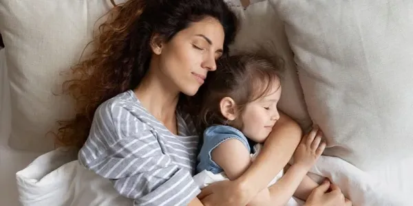 Mother and daughter sleeping peacefully in bed bug free bed